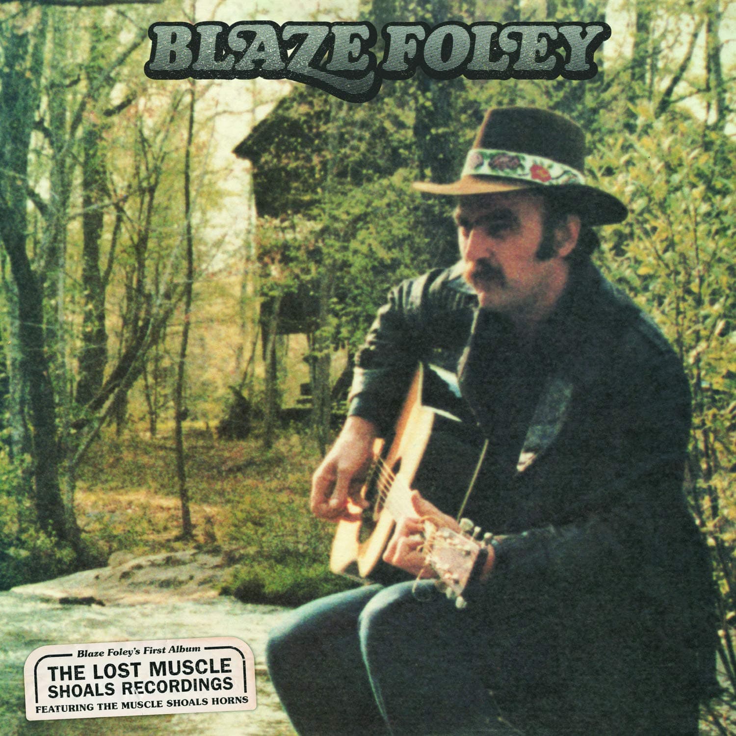 The original cover art for the Lost Muscle Shoals Recordings: a photograph of Blaze with a guitar outside his treehouse in Georgia